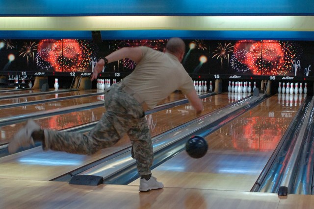 Spc. Robert Crump, with the 263rd Maintenance Company, Special Troops Battalion, 15th Sustainment Brigade, 13th Sustainment Command (Expeditionary), throws a bowling ball Jan. 27th at the Phantom Warrior Lanes as a part of Wagonmaster Stakes....