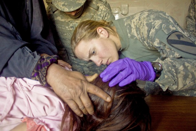 Pfc. Rachelle Halaska, a combat medic assigned to the 1st Squadron, 9th Cavalry Regiment, 4th Brigade Combat Team, 1st Cavalry Division, from Hartland, Wis., inspects a child's ear during a combined medical engagement at a clinic near Forward...