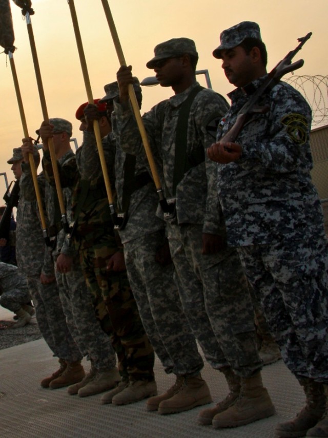 CAMP LIBERTY, Iraq - Multi-National Division - Baghdad Soldiers, along with an Iraqi Soldier and a National Policeman, ready themselves during a rehearsal in front of division headquarters on Camp Liberty Feb. 8.  The MND-B Honor Guard stands as a...