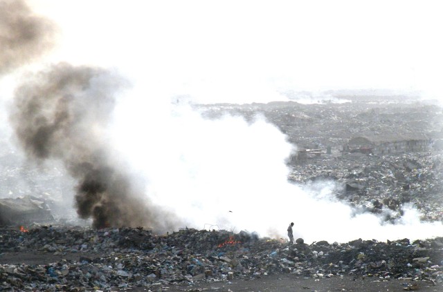 An Iraqi man makes room for more debris by burning the garbage to compact one of the local landfills in Baghdad Feb 7.  The 890th Engineer Battalion, 926th Engineer Brigade, Multi-National Division - Baghdad, conducts route clearance and sanitation p...