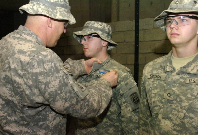 FORWARD OPERATING BASE LOYALTY, Iraq - Col. Timothy McGuire (far left), commander of the 3rd Brigade Combat Team, 82nd Airborne Division, Multi-National Division-Baghdad, pins the Combat Infantryman Badge on Pfc. Blake Buckley, of Sonoma, Calif.,...
