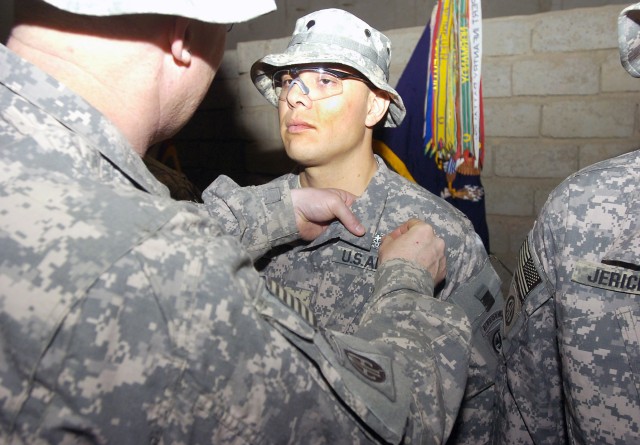 FORWARD OPERATING BASE LOYALTY, Iraq - Col. Timothy McGuire, commander of the 3rd Brigade Combat Team, 82nd Airborne Division, Multi-National Division-Baghdad,  pins the Combat Medical Badge on Pfc. Gasper Grijalva, during an award ceremony Feb. 5...