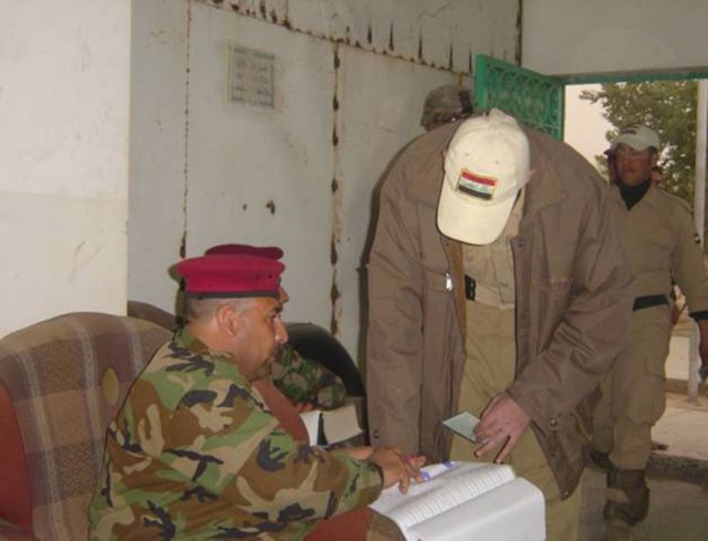 BAGHDAD - An Iraqi Army Soldier serving with the 2nd Battalion, 54th Brigade, 6th Iraqi Army Division oversees the payment of a member of the Sons of Iraq in the Mansour district of northwest Baghdad Feb. 10. The Government of Iraq continues to...