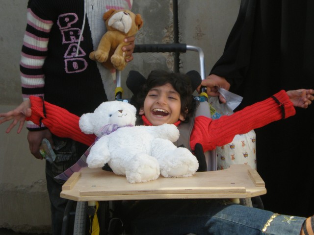 BAGHDAD-  Haneen, a 12- year- old disabled Iraqi girl, shows her happiness with her new wheelchair Feb. 7.  Haneen was one of three Iraqi children in Mahmudiyah to receive wheelchairs donated by Wheelchairs for Iraqi Kids.  Civil Affairs Team 31 assi...