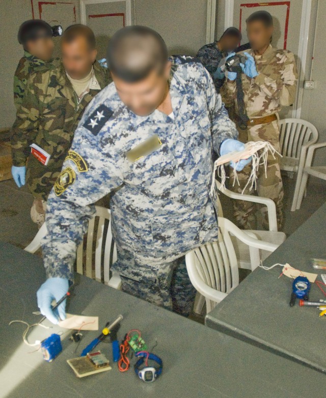 Iraqi Soldiers and police officers search a room used for bomb making for clues in a training environment at Camp Dhi Qar, the 10th Iraqi Army Division's headquarters, Feb. 10. With the IP and IA completely in the lead, the 4th Brigade Combat Team, 1...