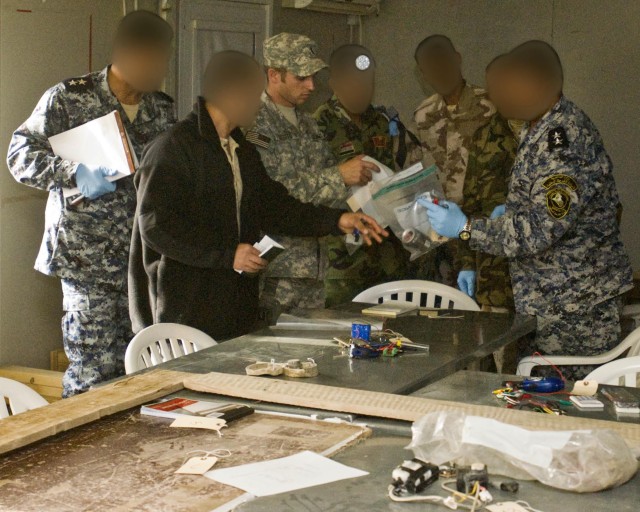 Chief Warrant Officer 2 Marc Losito reviews the finer points of the Iraqi Police and Iraqi Army investigation team's efforts in the hands-on training portion of the day's training at Camp Dhi Qar Feb. 10. With the IP and IA completely in the lead, th...