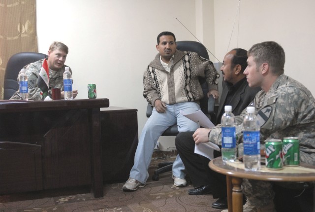 Lt. Col. Scott Kendrick, commander of the 2nd Battalion, 12th Cavalry Regiment, 4th Brigade Combat Team, 1st Cavalry Division and Cpt. Matthew Guevara, Civil Military Operations officer for the Thunder Horse Battalion, sit with Iraqi journalists...