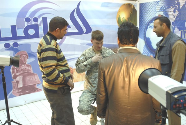 Cpt. Matt Prescott, commander of Co. A., 2nd Battalion, 12th Cavalry Regiment, 4th Brigade Combat Team, 1st Cavalry Division, puts on a microphone for his T.V. interview with the An-Nasr television and radio station in the Dhi Qar province Feb 11....