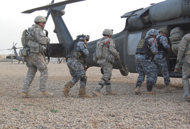 JOINT SECURITY STATION ISTAQLAL, Iraq - Soldiers assigned to 56th Stryker Brigade Combat Team, Pennsylvania Army National Guard, Multi-National Division-Baghdad, and National Police officers assigned to the 2nd Brigade, 1st NP Div., enter a UH-60 Bla...