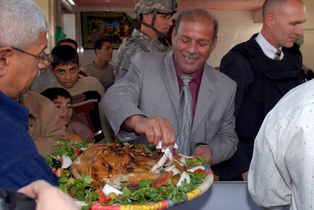 BAGHDAD - An Iraqi attending the re-opening ceremony of the Shawaka Fish Market takes a sample of freshly cooked fish Feb. 18. The United States Organization for International Development and members of the 2nd Heavy Brigade Combat Team, 1st...