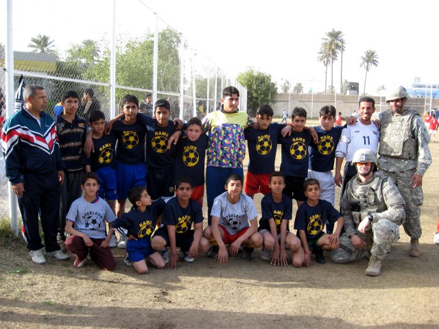 BAGHDAD - Multi-National Division - Baghdad Soldiers serving with the 4th Battalion, 42nd Field Artillery Regiment, pose with a youth soccer team before a tournament at the Zawra Soccer Stadium in the Karkh district of northwest Baghdad Feb. 17. The ...