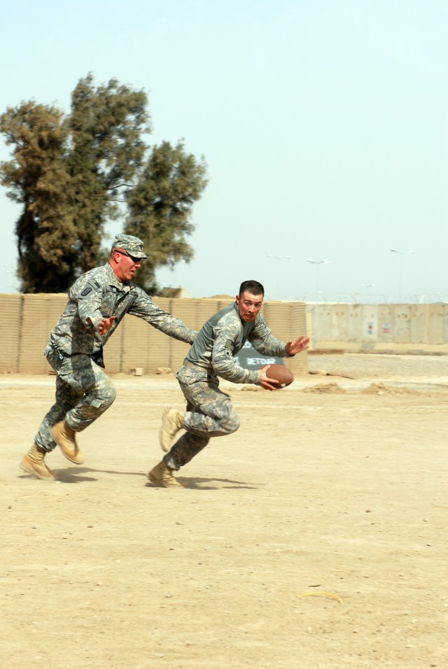 CAMP TAJI - Multinational Division - Baghdad Soldiers play an impromptu game of football at Camp Taji while waiting for their convoy to continue the mission Feb. 17.  Spc. Evan Lourie, from the 46th Engineer Battalion based out of Fort Polk, La., tri...