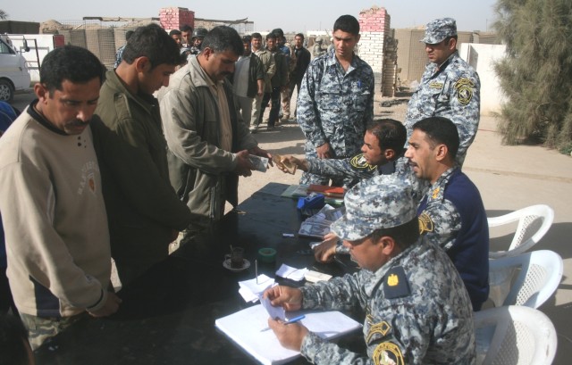 ISTAQLAL, Iraq -Iraqi National Police officials pay Sons of Iraq members Feb. 18 at in the Istaqlal Qada district of Baghdad. More than 500 SoI members were paid by NP officers assigned to the 2nd NP Brigade, 1st NP. The SoI have been credited for th...