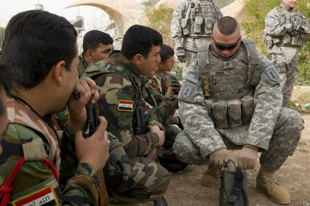 BAGHDAD - Sgt. Derrick Junge (right), 1st Battalion, 7th Field Artillery Regiment, 2nd Heavy Brigade Combat Team, 1st Infantry Division, Multi-National Division-Baghdad, trains Iraqi Army soldiers on the functions of radio communication equipment...