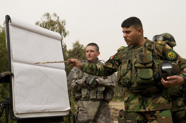 BAGHDAD -- Lt. Kareem of the Iraqi Army, assisted by 2nd Lt. John Worsencroft (back left), 1st Battalion, 7th Field Artillery Regiment,  2nd Heavy Brigade Combat Team, 1st Infantry Division, Multi-National Division-Baghdad, gives a class to his...