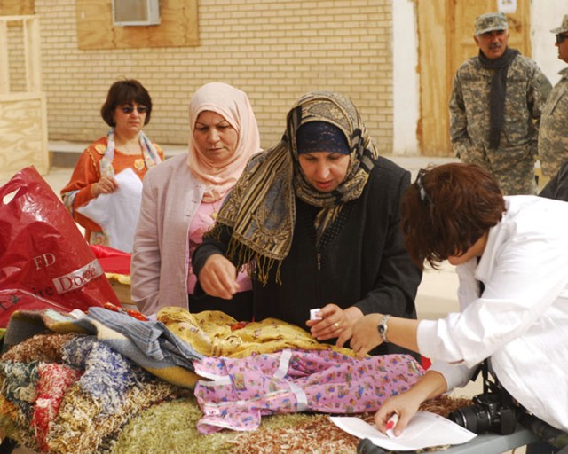 BAGHDAD- A local Iraqi woman from the Mahmudiyah Qada discusses her products with a customer during the Women's Bazaar hosted by Task Force 1st Combined Arms Battalion, 63rd Armor Regiment at FOB Mahmudiyah Feb 17.  Many of the women in the Mahmudiya...