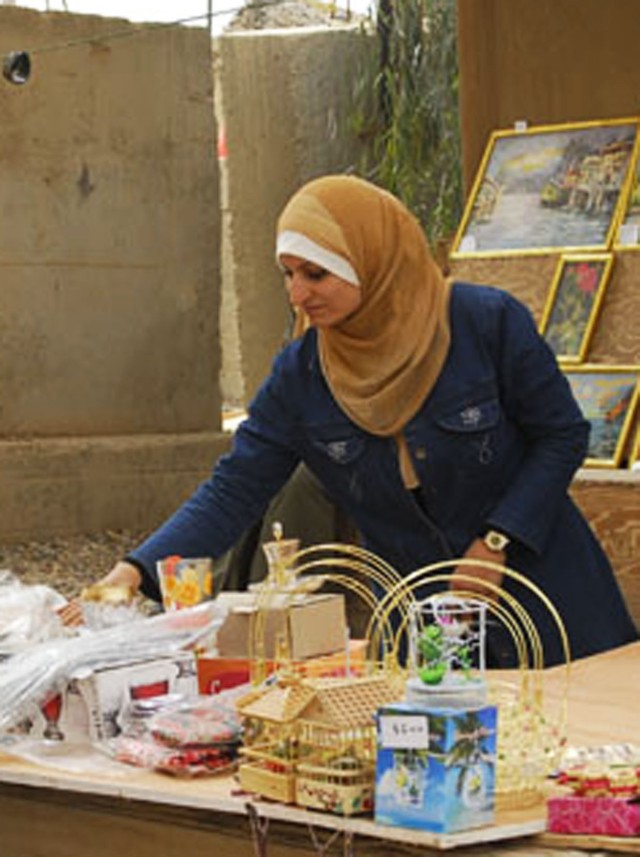 BAGHDAD-  A local Iraqi woman from the Mahmudiyah Qada arranges her table of merchandise during the Women's Bazaar hosted by Task Force 1st Combined Arms Battalion, 63rd Armor Regiment at FOB Mahmudiya, south of Baghdad, Feb 17. The unique program st...