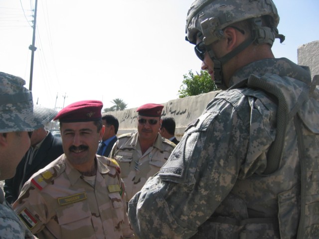 Baghdad - Lt. Col. Tahseen (left), commander, 2nd Battalion, 55th Brigade, 17th IA Division and Capt. Allan Carroll (right), of Kailua, Hawaii, commander, Company B, 1st Battalion, 35th Armor Regiment, meet outside the clinic in Adwaniyah, Feb....