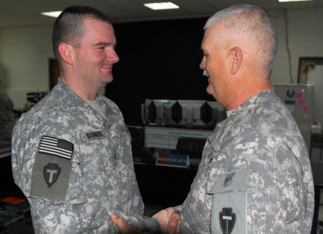 BAGHDAD - Sgt. Jason Summers (left), with Headquarters and Headquarters Company, 56th Infantry Brigade Combat Team, 36th Infantry Division, receives a handshake of congratulations from Command Sgt. Maj. John Morgan III, senior enlisted leader,...