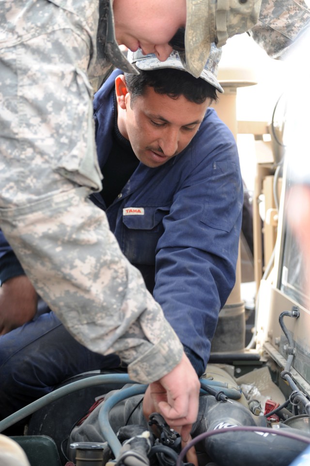 JOINT SECURITY STATION BELADIYAT, Iraq - Spc. Christopher Parker (left), a native of Portland, Tenn., 2nd Battalion, 505th Parachute Infantry Regiment, 3rd Brigade Combat Team, 82nd Airborne Division, shows an National Police mechanic assigned to the...