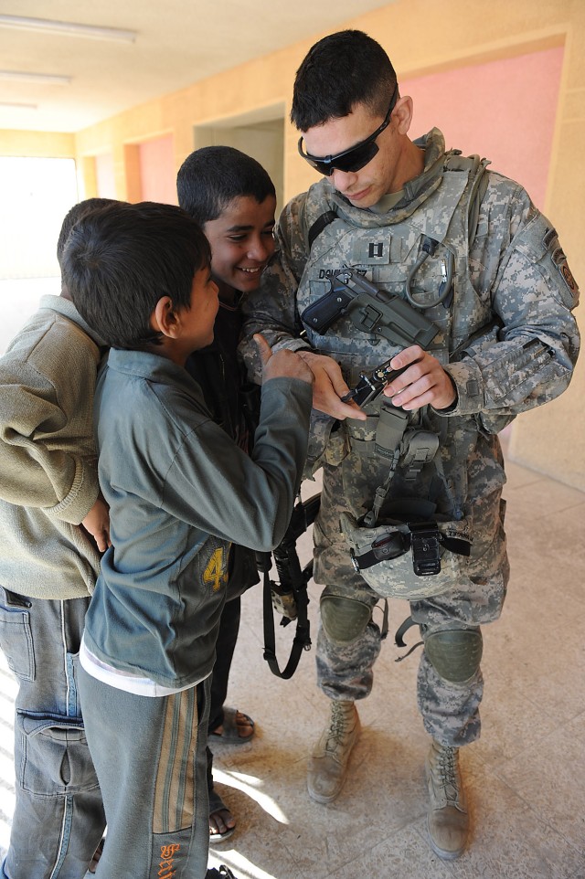 BAGHDAD - Capt. Agustin Dominguez, a fire support officer assigned to 2nd Battalion, 505th Parachute Infantry Regiment, 3rd Brigade Combat Team, 82nd Airborne Division, Multi-National Division-Baghdad , shows Iraqi children his camera screen after ta...