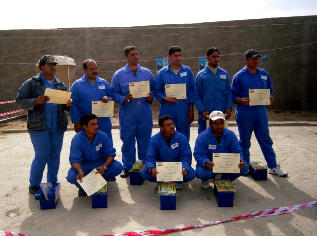 BAGHDAD - The graduating class of a generator repair course pose with their diplomas and tool sets presented to each graduate for their successful completion of the course.  The Feb. 23 ceremony was held in the Karkh district of northwest Baghdad...