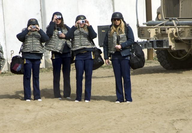 Three cheerleaders with the St. Louis Rams of St. Louis, Miss. take pictures of combat outpost Courage's main building, a palace that was at one time inhabited by one of Saddam Hussein's daughters in Mosul, Iraq. The grounds are now used by assets...