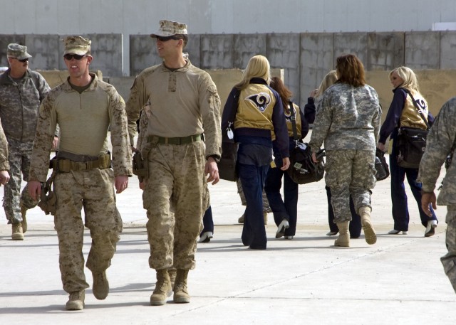 Cheerleaders with the St. Louis Rams of St. Louis, Miss. are a stark contrast to the neutral colored fatigues that are normally seen at forward operating base Sykes near Taji, Iraq. The girls stopped here for lunch after a long morning of touring...