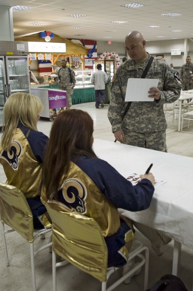 Spc. Garry Beals, with D Troop, 6th Squadron, 9th Cavalry Regiment from McPherson, Kan., has posters signed by five cheerleaders with the St. Louis Rams. The cheerleaders ate lunch at the dining facility on forward operating base Sykes near Taji,...