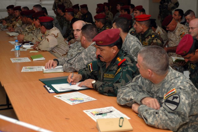 Officers from the 12th Iraqi Army Division and 2nd Brigade Combat Team, 1st Cavalry Division, sit side by side in a meeting at K-1, a military base in Kirkuk Province, Iraq, Feb. 5. Many of the leaders are meeting for the first time. The meeting...