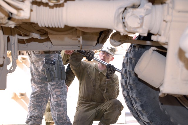 BAGHDAD - Spc. Thomas Parker, a light-wheeled vehicle mechanic from Salem, Ore., deployed with Headquarters Support Company, Division Special Troops Battalion, 1st Cavalry Division uses a torque wrench to tighten a bolt on a Mine-Resistant Ambush...