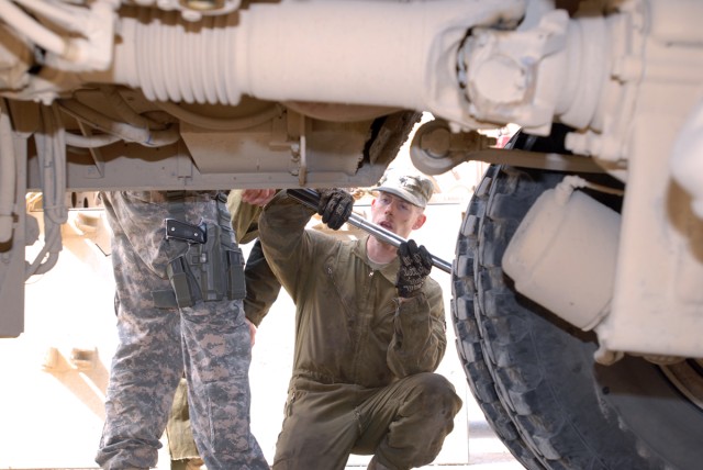 BAGHDAD - Spc. Thomas Parker, a light-wheeled vehicle mechanic from Salem, Ore., deployed with Headquarters Support Company, Division Special Troops Battalion, 1st Cavalry Division uses a torque wrench to tighten a bolt on a Mine-Resistant Ambush Pro...