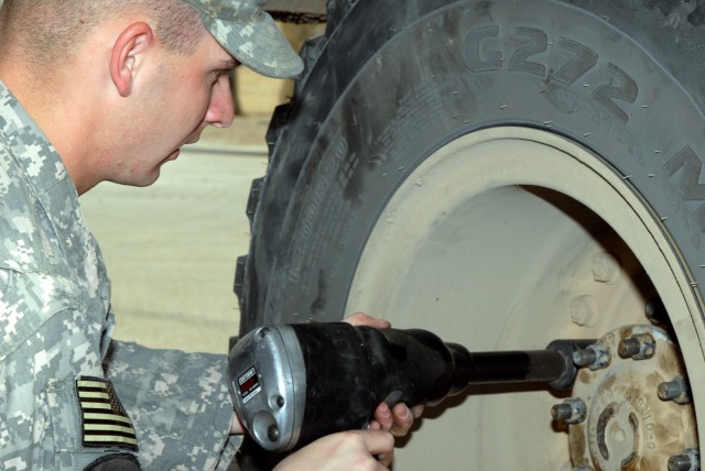 BAGHDAD - Spc. Anthony Theriot, a tactical vehicle operator from Atlanta deployed with D Troop, Division Special Troops Battalion, 1st Cavalry Division, puts a tire back on a Mine-Resistant Ambush Protected vehicle after  completing repairs Feb....