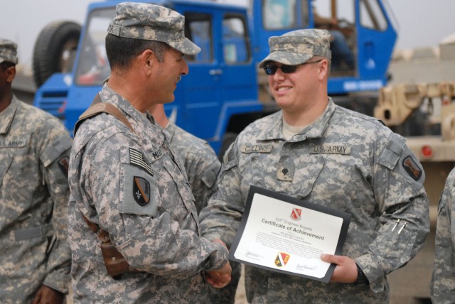 CAMP LIBERTY, Iraq - Jackson Miss., native Spc. Michael Collins (right), a member of Company A, 890th Engineer Battalion, 225th Engineer Brigade, 1st Cavalry Division, Multi-National Division-Baghdad, receives a certificate of achievement from...