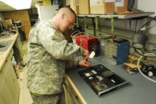 BAGHDAD - Spc. Mathew Fischer, of Delphos, Ohio, who serves with the 47th Forward Support Battalion, 2nd Brigade Combat Team, 1st Armored Division, works on a computer in the electronics maintenance section on Camp Striker, Feb. 19. Fisher stays...