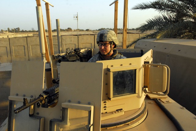 BAGHDAD - Spc. James Ott, of Oscala Fla., with the 4th Battalion, 27th Field Artillery Regiment, 2nd Brigade Combat Team, 1st Armored Division, conducts personal combat checks on his M-240B machine gun from the turret of his Mine Resistant Ambush...