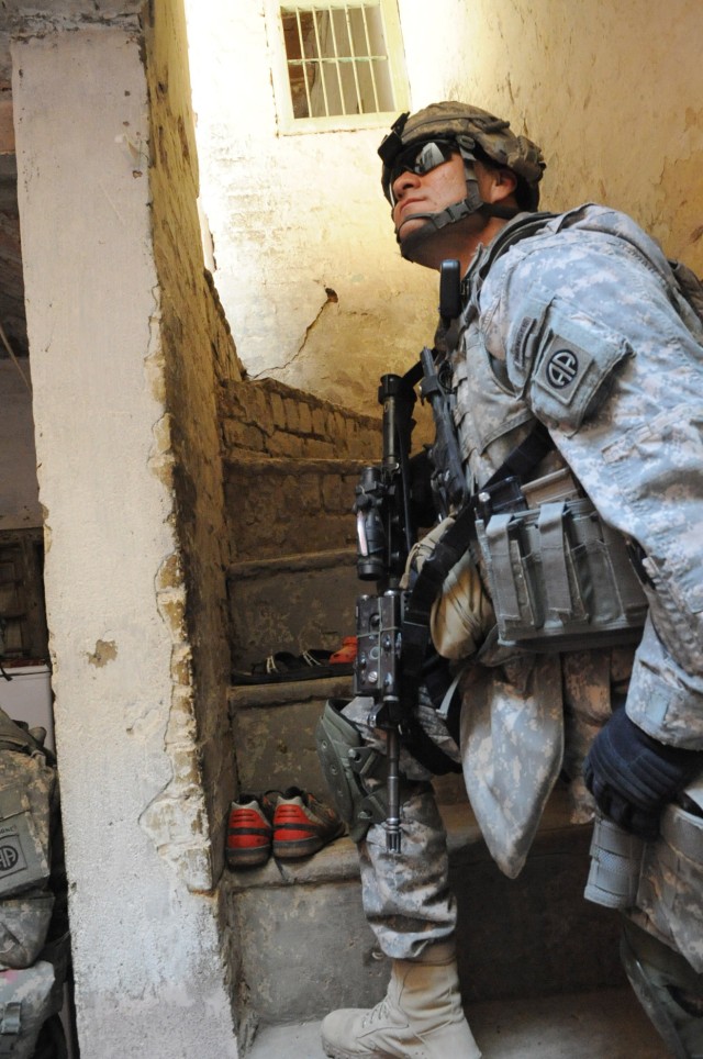 RASHEED, Iraq - Capt. Frank Rodriguez, of Cameron, N.C., commander of  Troop A, 5th Squadron, 73rd Cavalry Regiment, 3rd Brigade Combat Team, 82nd Airborne Division, looks at the top of a stairway while clearing a house during Operation Sway Sway...