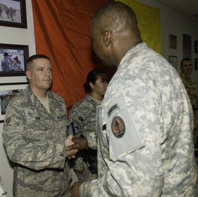 Lt. Gen. Lloyd Austin III, the commander of Multi-National Corps - Iraq, presents a commendation coin to Sr. Airman Randy Hare, a heavy equipment operator working in the 14th Engineer Battalion, at the Long Knife Brigade headquarters in...