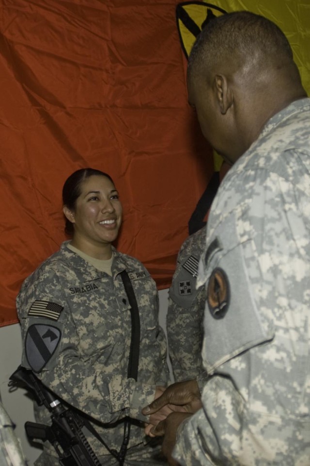 Lt. Gen. Lloyd Austin III, the commander of Multi-National Corps - Iraq, presents a commendation coin to Spc. Cecilia Sarabia, a combat medic in the Special Troops Battalion, 4th Brigade Combat Team, 1st Cavalry Division, at the Long Knife Brigade...