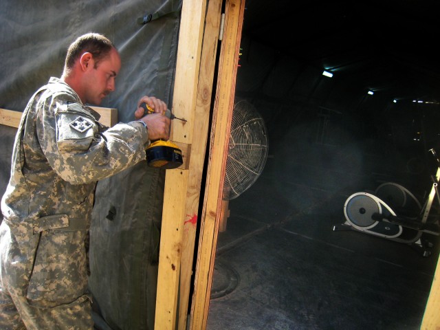 Sgt. David Crabb, a Black Dragon trooper from Colchester, IL, assembles the frame on the doorway to the new gym at Forward Operating Base Hunter, Iraq. The incoming Black Dragon troops are expanding the base to house the battalion's field...
