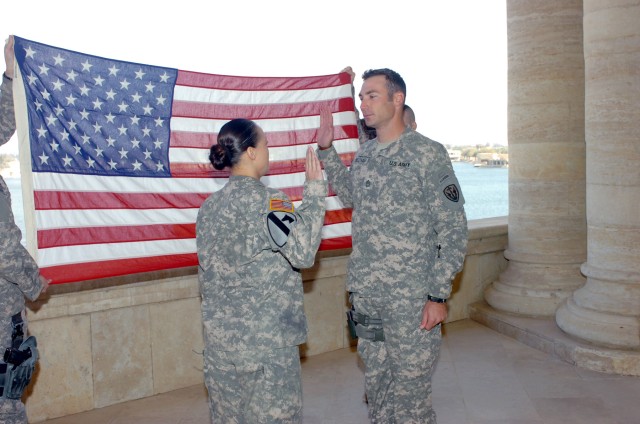 VICTORY BASE COMPLEX, Iraq - Cape Coral, Fla. native Sgt. 1st Class Shane Beckham (right), a military intelligence noncommissioned officer for the 303rd Military Intelligence Battalion, receives the oath of enlistment from his wife, Chief Warrant...