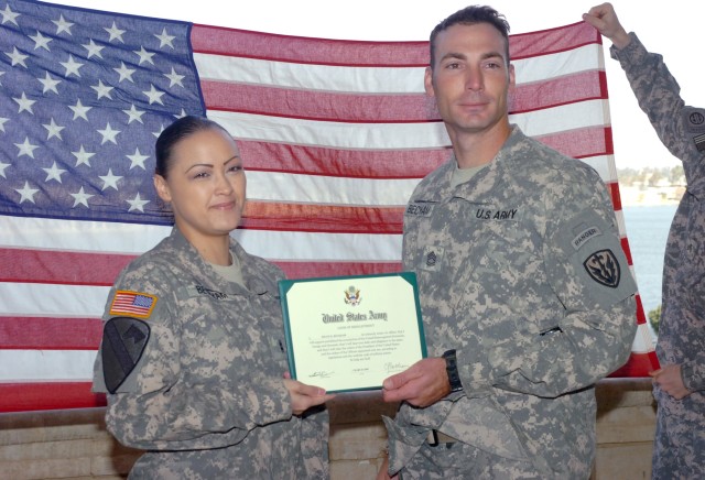 VICTORY BASE COMPLEX, Iraq - With friends and fellow Soldiers in attendance, Chief Warrant Officer 2 Chastity Beckham (left) and Sgt. 1st Class Shane Beckham, who have been married for eight years, pose for a photo during Shane's reenlistment...