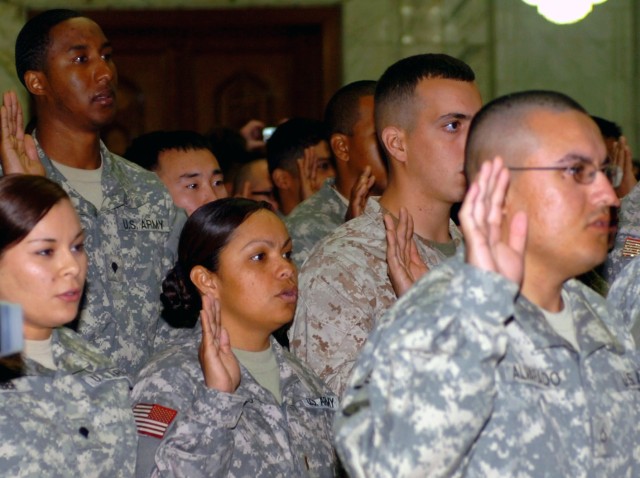 VICTORY BASE COMPLEX, Iraq - Amid a sea of other service members also taking the oath of citizenship, 2nd Lt. Memorina Edwin Barnes (center), executive officer, Headquarters Service Battery, Division Special Troops Battalion, 1st Cavalry Division,...