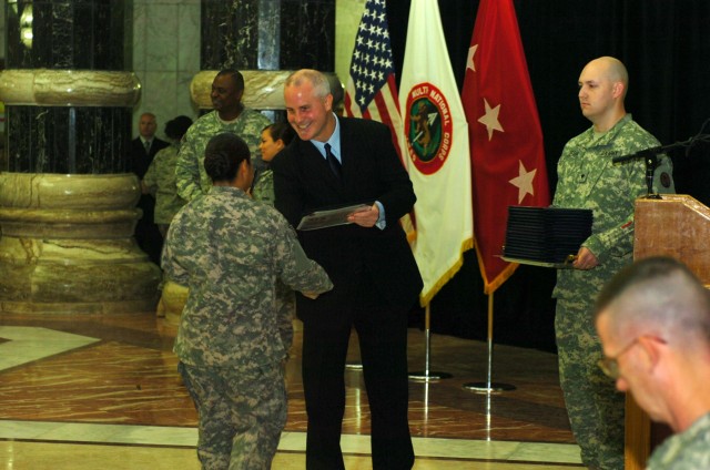 VICTORY BASE COMPLEX, Iraq - John Lafferty, district director for the United States Citizen and Immigration Service, based out of Rome, Italy, presents the certificate of U.S. citizenship to 2nd Lt. Memorina Edwin Barnes, executive officer for...