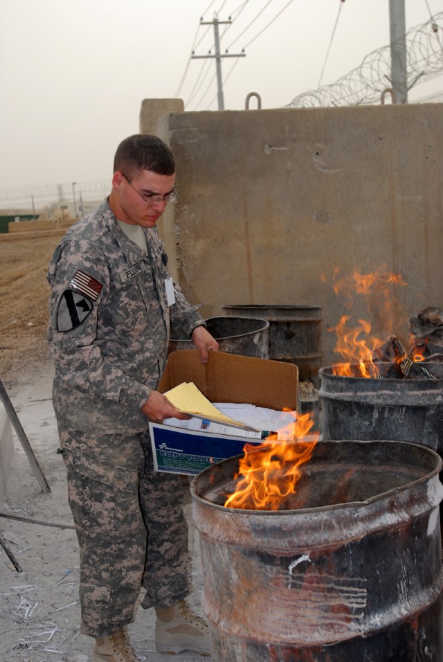 CAMP LIBERTY, Iraq -Spc. Jonathan Fillion, a satellite communications operator maintainer with Company C, Division Special Troops Battalion, 1st Cavalry Division, burns documents in burn barrels.  According to Master Sgt. Mario Dovalina, operational ...