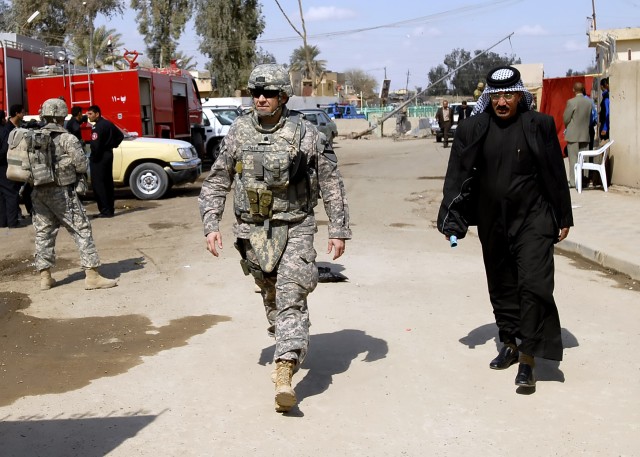 Lt. Col. Philip Smith (left), public affairs officer, Multi-National Division-Baghdad, walks the streets of the Shulla neighborhood of northwest Baghdad during a media walk-through, March 2. Shortly before the walk-through, various Arabic and western...