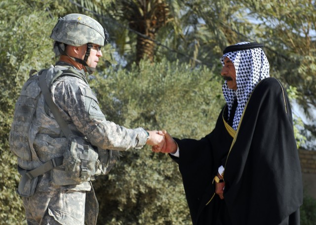 MAHMUDIYAH, Iraq - Col. Pat White, commander, 2nd "Iron" Brigade Combat Team, 1st Armored Division, Multi-National Division-Baghdad, shakes hands with a local Sheik after a meeting held in Mahmudiyah Feb. 25. During the meeting, MND-B  leaders and th...