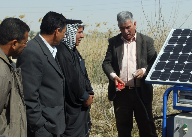 BAGHDAD - Nadhel, an Iraqi engineer explains how a solar powered water purifier works after it was given to the village of Lutifiyah during a ceremony  attended by local sheiks, villagers and Soldiers from the 1st Combined Arms Battalion, 63rd...