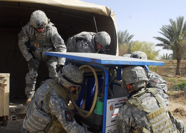 BAGHDAD - Soldiers of the scout sniper team attached to Company A, 1st Combined Arms Battalion, 63rd Armor Regiment, 2nd Brigade Combat Team, 1st Armored Division,  Multi-National Division- Baghdad unload a solar powered water purifier which was...