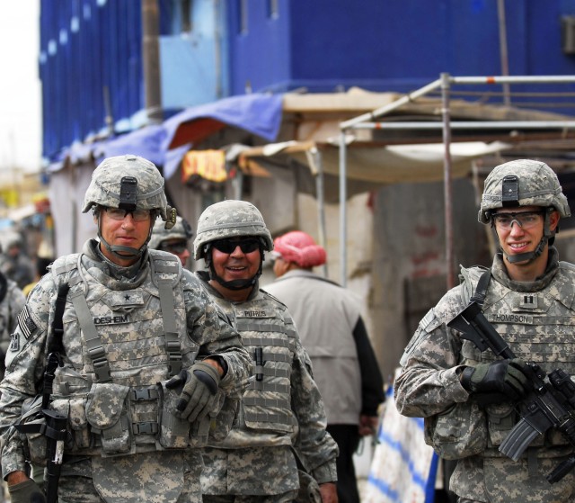 BAGHDAD - Brig. Gen. Frederick S. Rudesheim (left), deputy commanding general for support, 1st Cavalry Division and Multi- National Division- Baghdad, walks through the Doura market with Capt. Michael Thompson (right) of Vienna, Va., commander,...